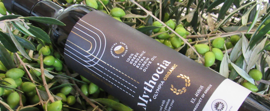 Mythocia olive oil bottle among olives