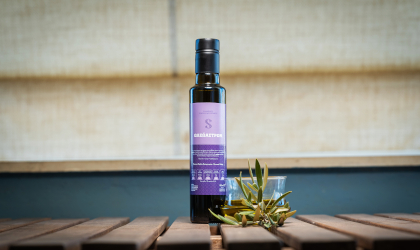 a bottle of Sakellaropoulos Organic Farms' Oleastron flavored olive oil on a table