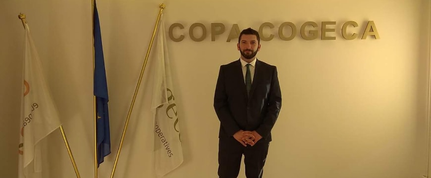 Vasilis Pyrgiotis standing in front of a Copa-Cogeca sign, next to three flags