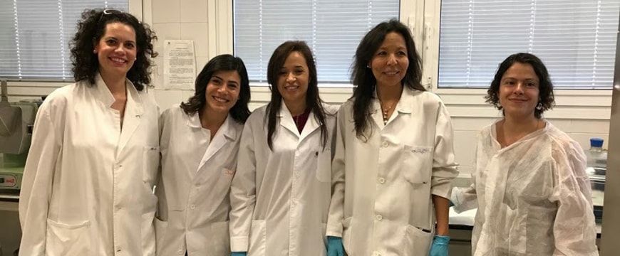Irini Kokolaki and her classmates in white lab coats in an olive oil tasting lab in Jaen, Spain