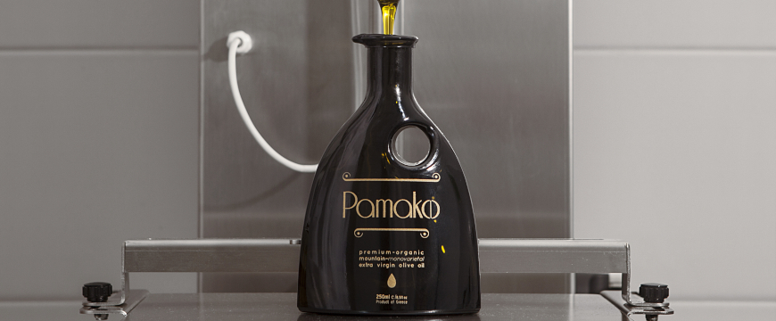 a dark glass bottle of Pamako being filled in the bottling plant