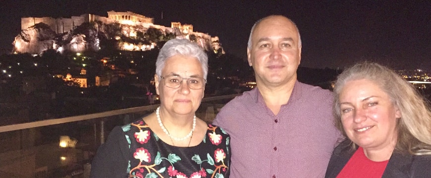 Professor Magda Tsolaki, Yannis and Evi Prodromou, with the Acropolis in the background, at night