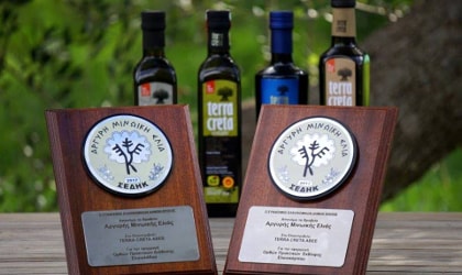 Terra Creta's latest awards in front of some bottles of their olive oil