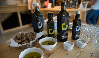 Anoskeli olive oil bottles, bowls of olive oil, rusks, and small tasting glasses