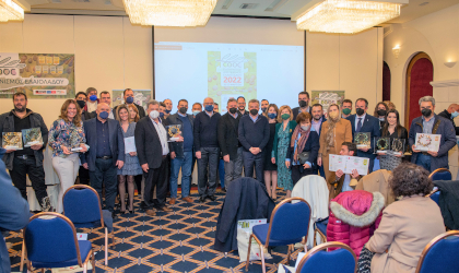 Cretan olive oil competition winners posing at the front of a room full of chairs