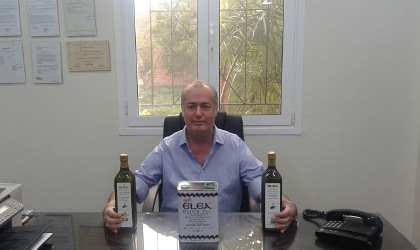 Loutraki Oil Company's Athanasios Katsetos at his desk, with Elea olive oil containers on it