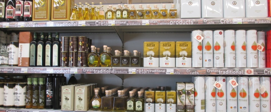 A variety of olive oil bottles on the shelves of a Greek supermarket