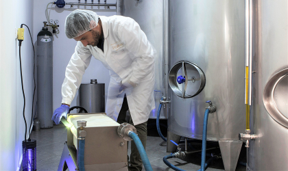 Eftychios Androulakis filtering his olive oil next to storage vats