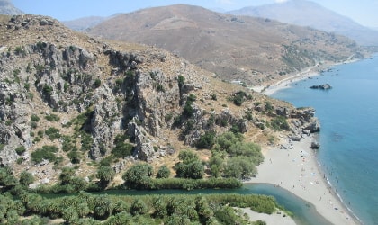 View of river, palm trees, beach, sea, and hills at Preveli, Crete
