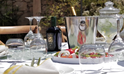 A table with olive oil, salad, glassware, and dishes (viewed from the side)