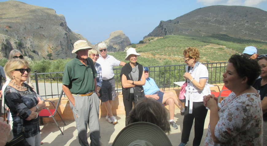 visitors learning about olive oil at Biolea, with hills and sky in the background