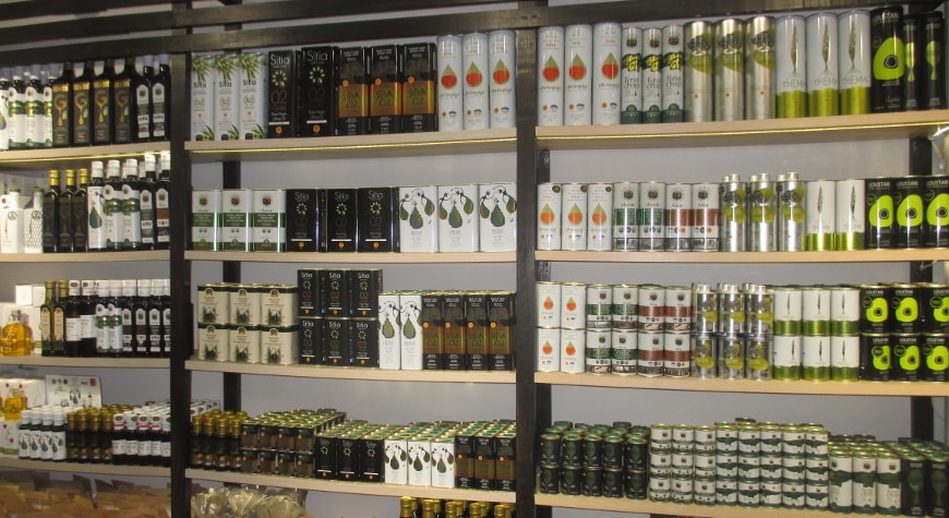 a variety of bottles and tins of Cretan olive oils on the shelves in the Kipsel shop in Sitia