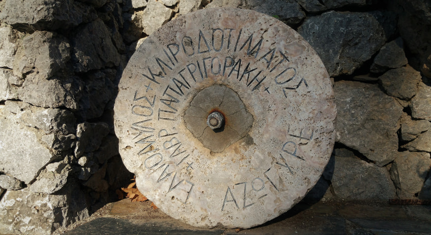 an old millstone with Greek words inscribed on it