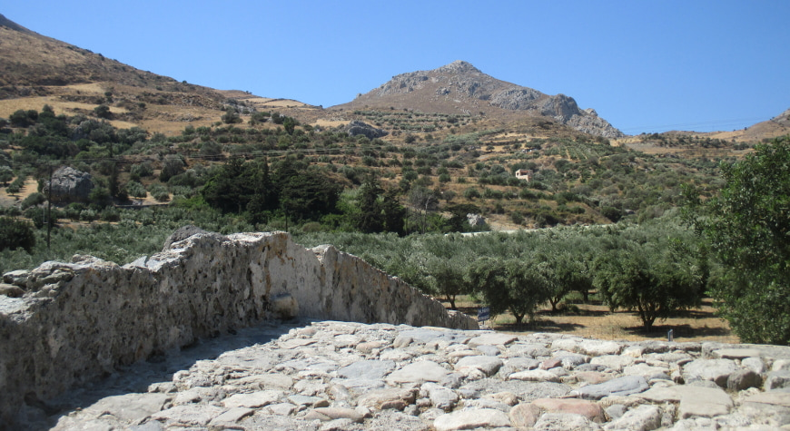 olive groves beyond the top of a stone bridge