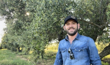 Laconiko co-owner Dino Pierrakos in front of one of the family's olive trees in their grove