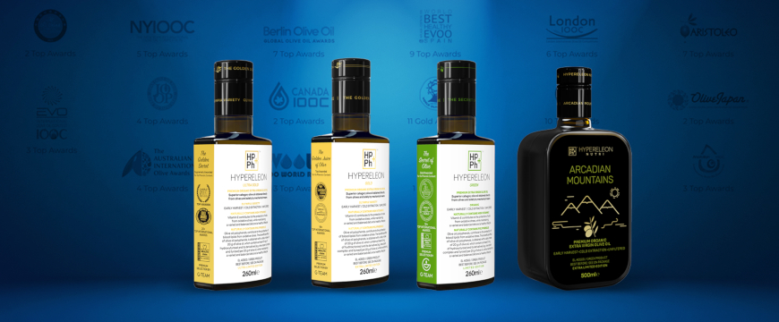4 bottles of Hypereleon extra virgin olive oil in a row, with the logos of olive oil competitions where they won awards on a blue background