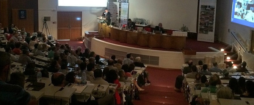 Speakers and audience in a semi-darkened auditorium at the Oleocanthal International Society conference in Ancient Olympia, Greece