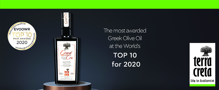 a bottle of Terra Creta Grand Cru with the EVOOWR Top 10 badge to the left, the words "the most awarded Greek olive oil at the world's top 10 for 2020" at the right, and the Terra Creta logo at the far right 