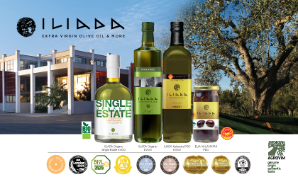 Bottles of Iliada olive oil and olives with a building and tree in the background and award images below it all
