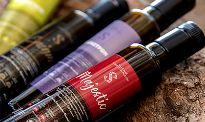 a variety of dark bottles of Sakellaropoulos olive oil, lying on their sides