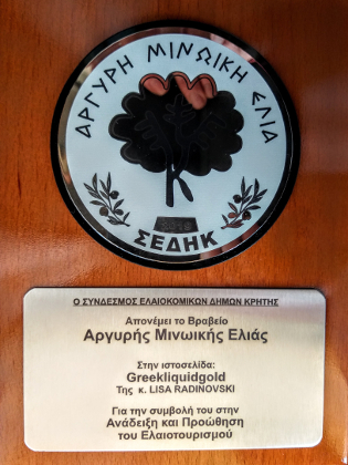 A plaque with a stylized olive tree and text about the silver award for the Greek Liquid Gold website