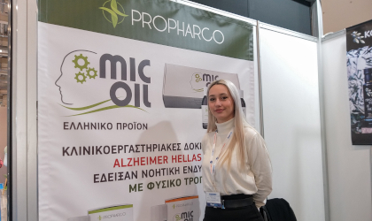 a young woman standing next to a banner about MICOIL products