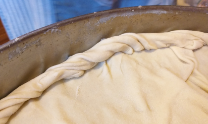 A closeup of the edge of the spanakopita crust, showing how it has been rolled up and twisted at the edge