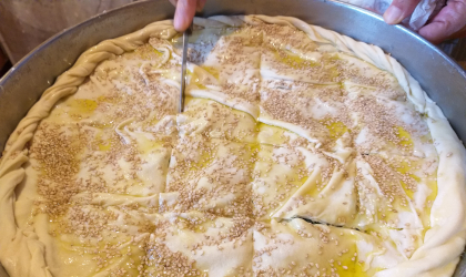 a knife cutting through the top 2 layers of phyllo dough before the pie goes into the oven
