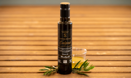 a bottle of Sakellaropoulos Organic Farms' Flavored Gourmet Enigma olive oil on a table