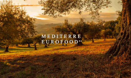 an olive grove bathed in sunset light, with hills in the background, and the words 
