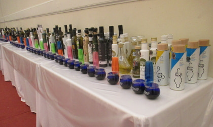 many bottles of Greek olive oil lined up on a table