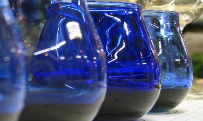 several blue olive oil tasting glasses next to each other