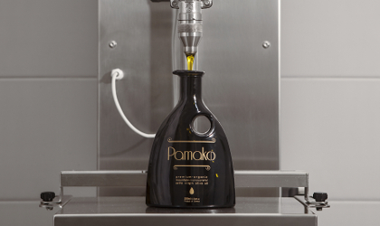 a black glass Pamako bottle being filled with olive oil
