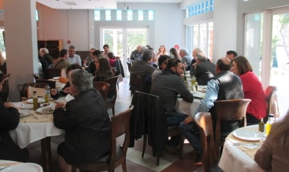 People sitting at tables eating olive oil snacks on World Olive Day