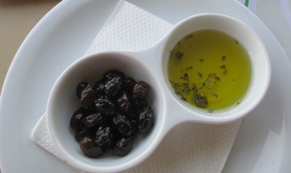 Small bowls of olive oil and olives