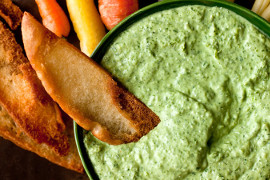 Bowl of this green dip with pita bread wedges