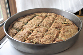 baked spanakopita in a large round pan